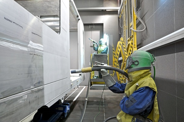 Scissors-type lifting platform in a blastroom for rolling stock vehicle